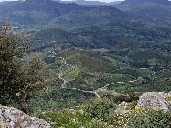 View from the summit across wooded hills and a winding road